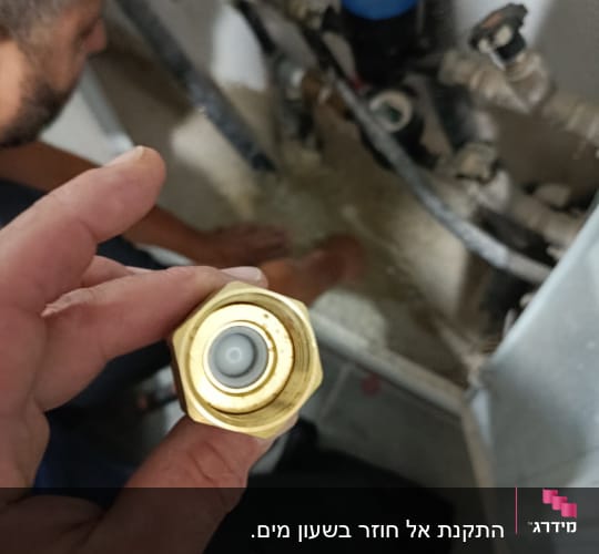 אדם עובד על צנרת עם כלי עבודה